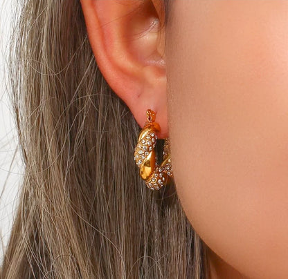 Gold plated twisted hoops with zircons on a model
